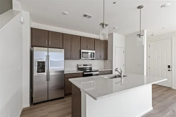 a kitchen with kitchen island a sink stainless steel appliances and cabinets