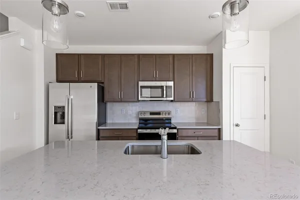 a kitchen with a refrigerator a stove a microwave and cabinets