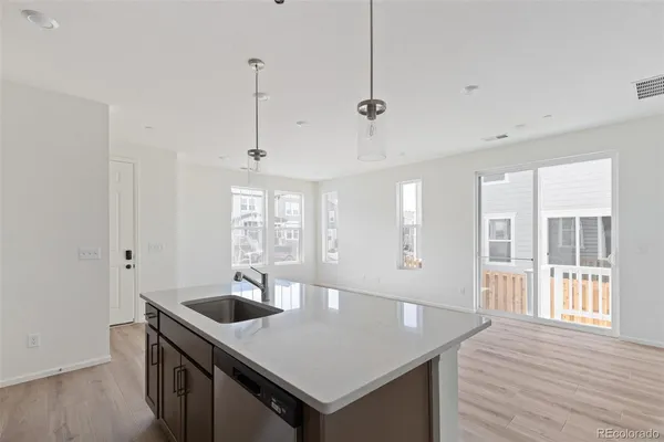 a kitchen with stainless steel appliances granite countertop a sink a oven and wooden floors