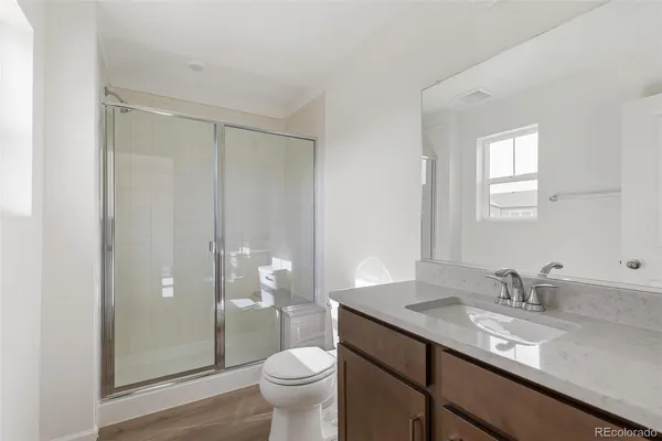 a bathroom with a granite countertop sink toilet and shower