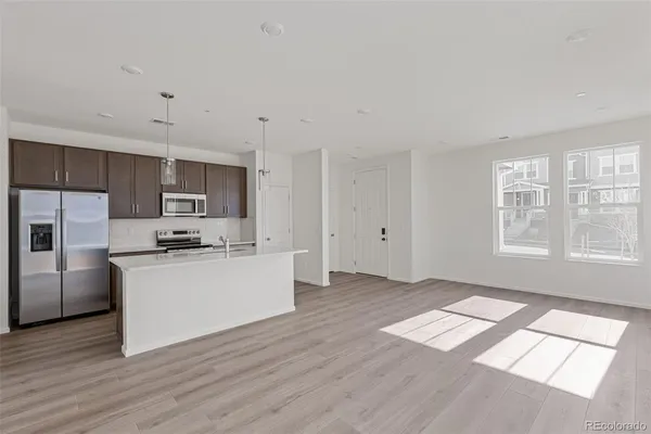 a kitchen with stainless steel appliances a refrigerator sink and microwave