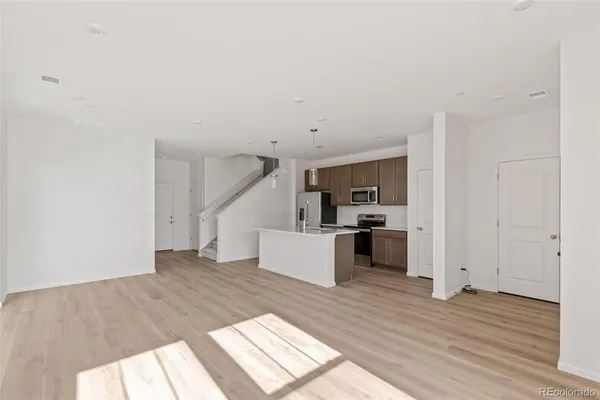a view of a kitchen with wooden floor and electronic appliances