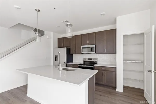 a kitchen with kitchen island a sink stainless steel appliances and cabinets