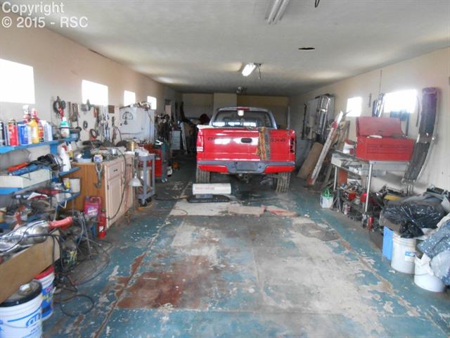 8860 Ermel Road Fountain, CO 80817 - Photo 4 of 5 Tandum garage, work shop, note all shelves and work space