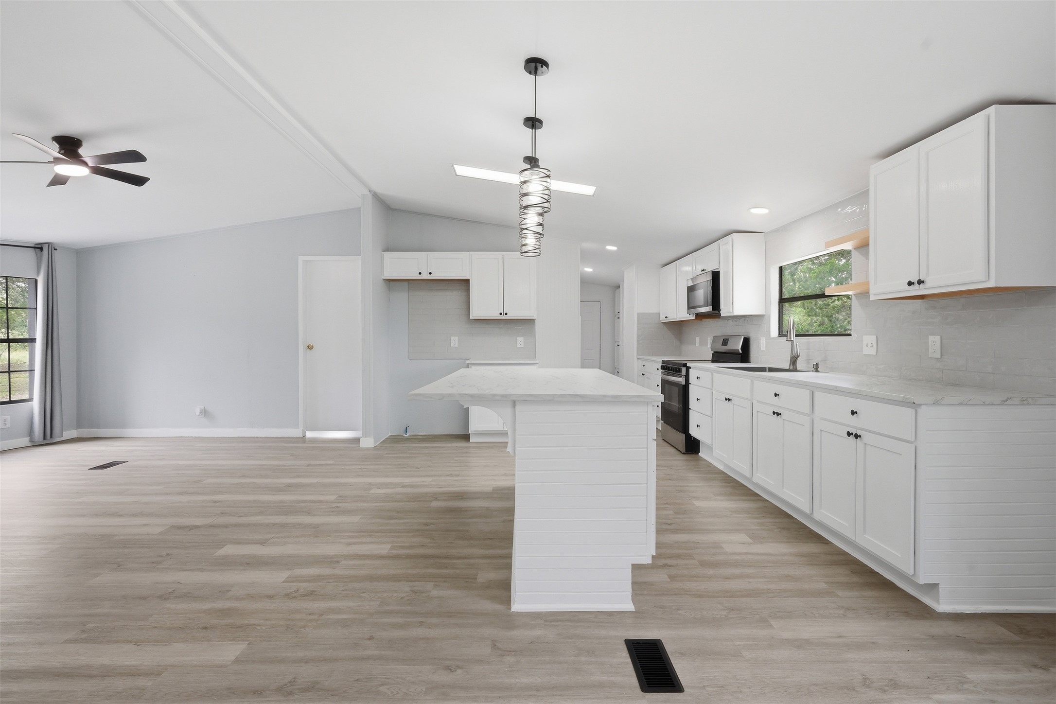 154 Antioch Road Smithville, TX 78957 - Photo 7 of 32 A well-lit kitchen with sleek appliances seamlessly flows into a spacious living area.
