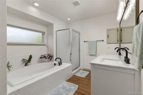 a bathroom with a tub sink and mirror