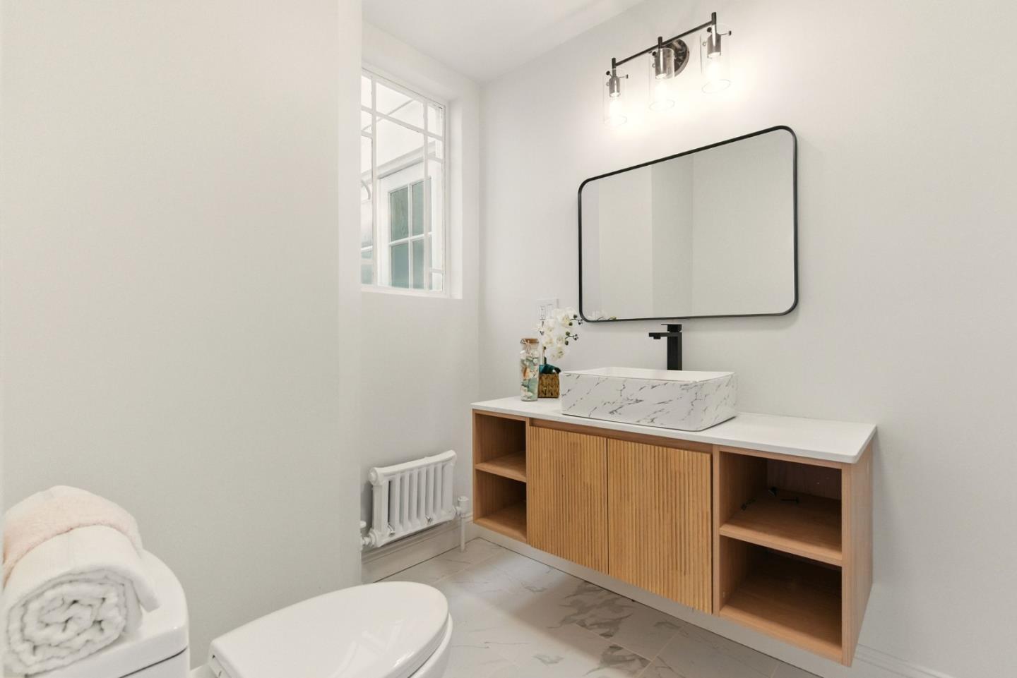 244 Lakeside Drive, Unit 202 Oakland, CA 94612 - Photo 26 of 32 a bathroom with a toilet sink and mirror