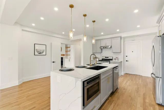 a kitchen with stainless steel appliances granite countertop a stove and a refrigerator