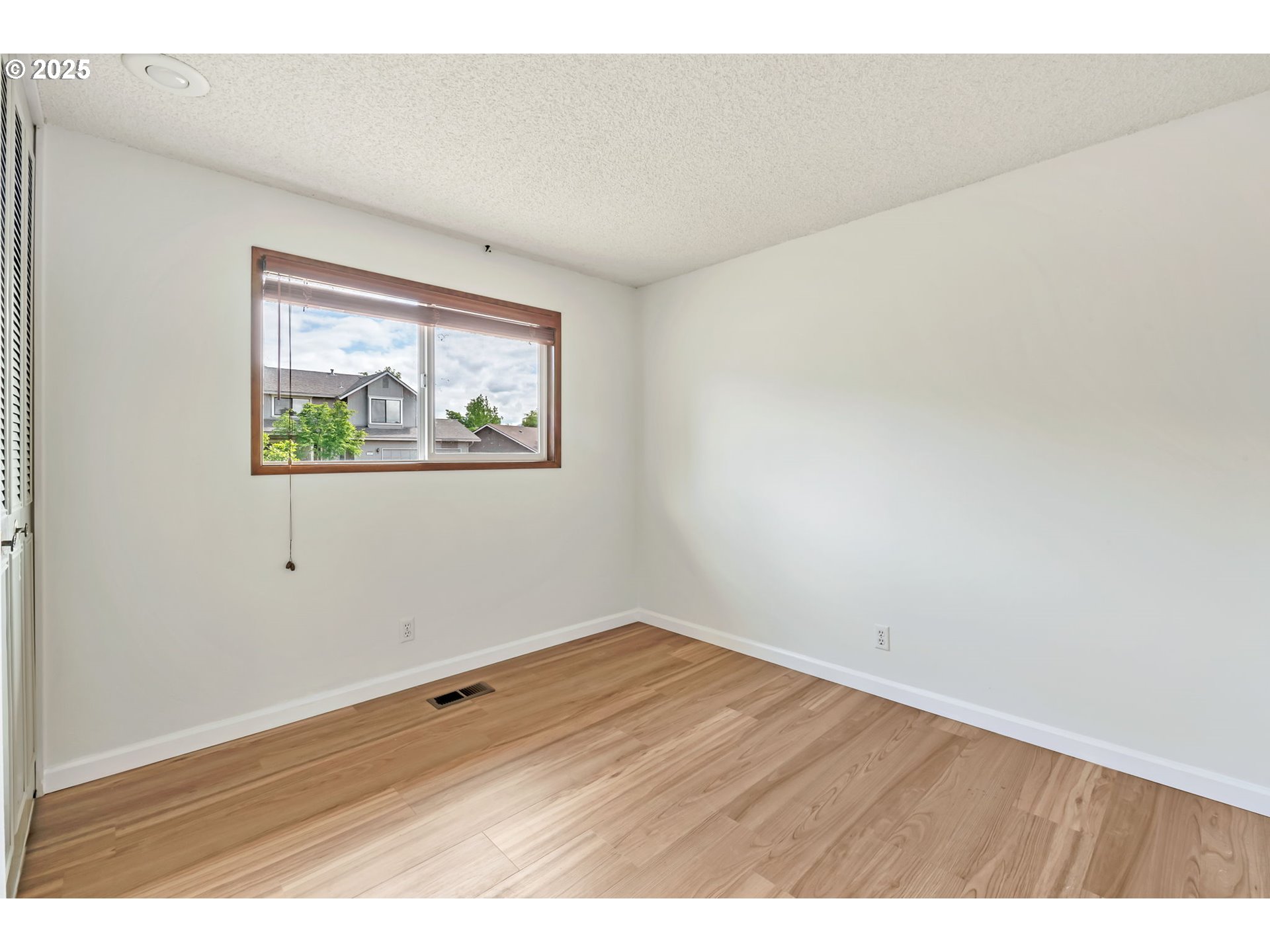 590 Granite Place Springfield, OR 97477 - Photo 12 of 21 an empty room with wooden floor and windows