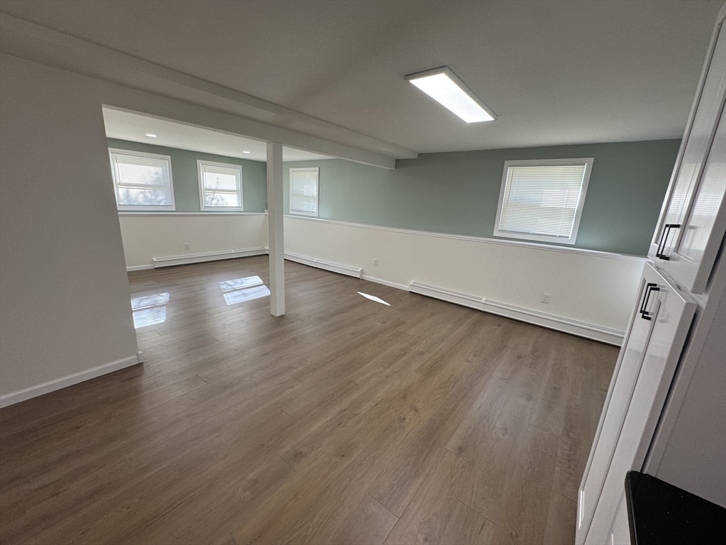 77 Cranston Street, Unit 1 Westfield, MA 01085 - Photo 2 of 11 an empty room with wooden floor and windows