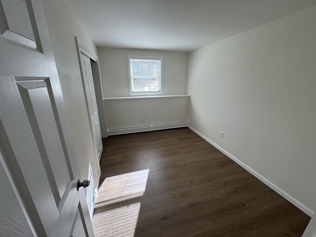 77 Cranston Street, Unit 1 Westfield, MA 01085 - Photo 5 of 11 an empty room with wooden floor and windows