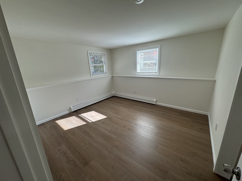 77 Cranston Street, Unit 1 Westfield, MA 01085 - Photo 7 of 11 an empty room with wooden floor and windows