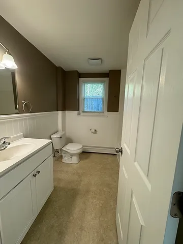 a bathroom with a double vanity sink toilet and mirror