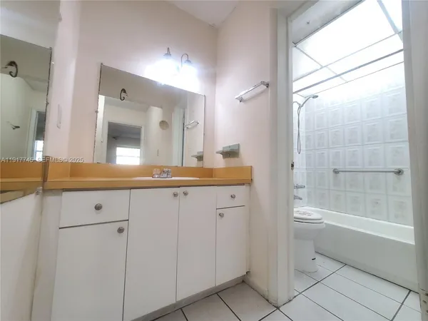 a bathroom with a tub a sink and a large mirror