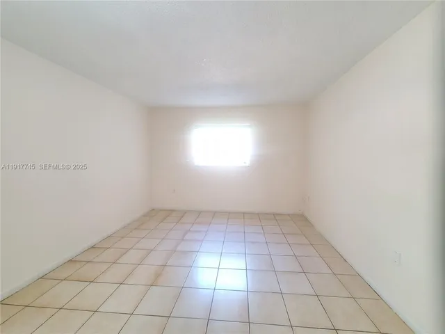 an empty room with white walls and tiles