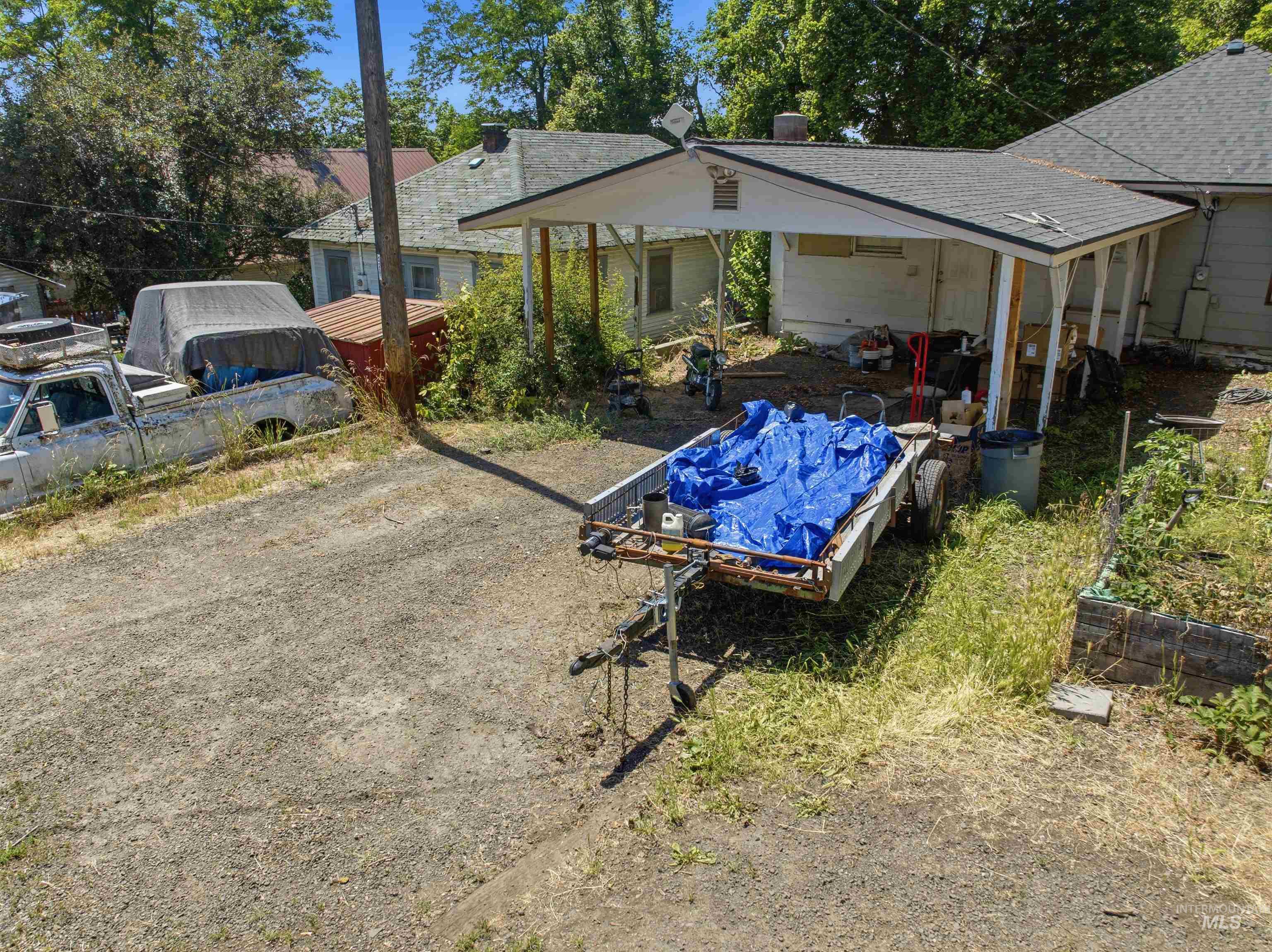 735 Oak Street Potlatch, ID 83855 - Photo 13 of 30 Gravel driveway leading to a carport structure with a shingled roof