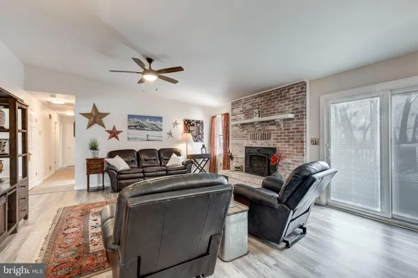 a kitchen with granite countertop a stove a sink a kitchen island a refrigerator cabinets and wooden floor