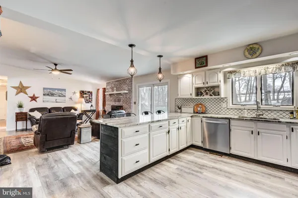 a kitchen with stainless steel appliances a table chairs refrigerator and sink