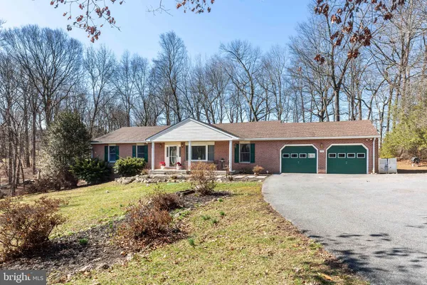 a front view of a house with a yard covered in snow