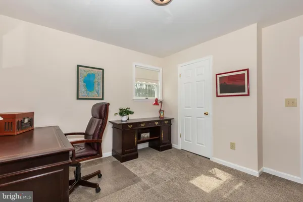 a living room with furniture a piano and a bookshelf