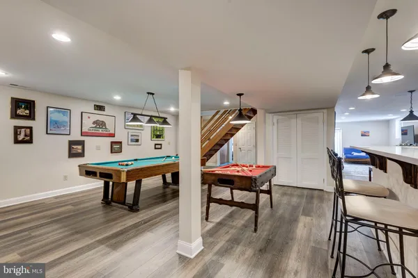 a kitchen with stainless steel appliances granite countertop a refrigerator a stove top oven a sink dishwasher and white cabinets with wooden floor