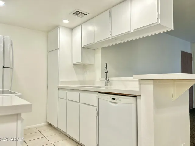 a kitchen with stainless steel appliances granite countertop a sink and a white cabinets