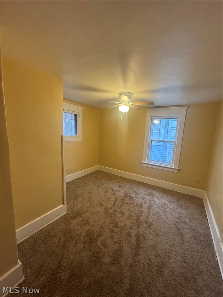 577 Rhodes Avenue Akron, OH 44307 - Photo 9 of 19 Empty room with dark colored carpet and a ceiling fan