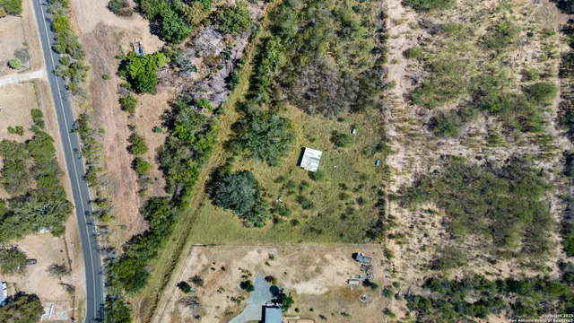 an aerial view of a house with a yard and large trees