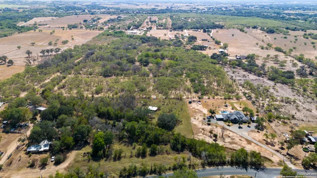 an aerial view of residential houses with outdoor space and trees