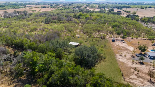 an aerial view of residential houses with outdoor space and trees