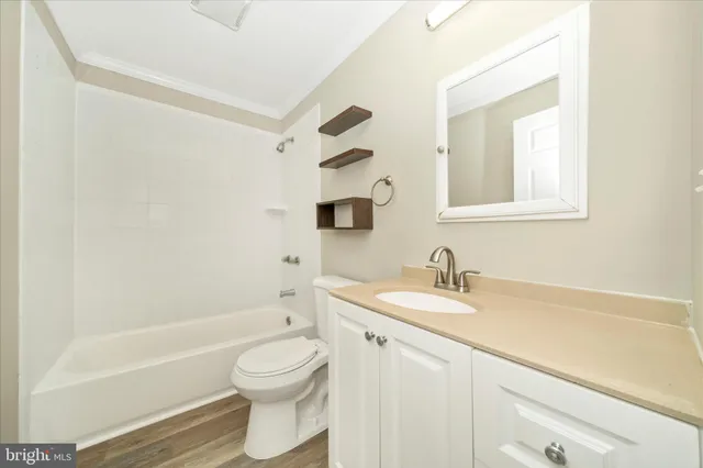a bathroom with a granite countertop sink toilet a mirror and bathtub
