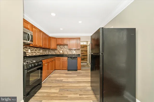 a kitchen with stainless steel appliances granite countertop a refrigerator and a stove top oven