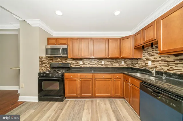 a kitchen with stainless steel appliances granite countertop a stove sink and cabinets