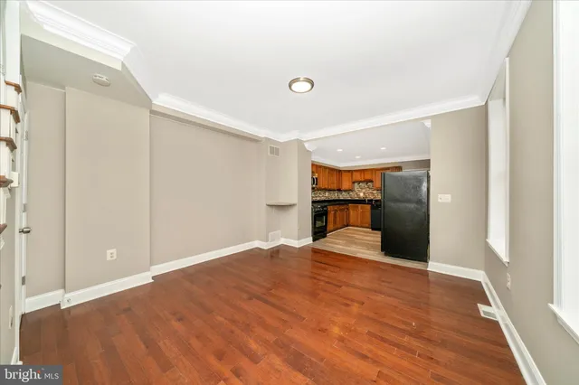 a view of empty room with wooden floor
