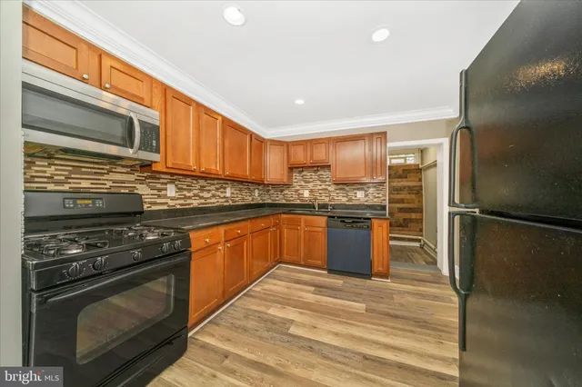 a kitchen with stainless steel appliances granite countertop a stove a refrigerator and a sink