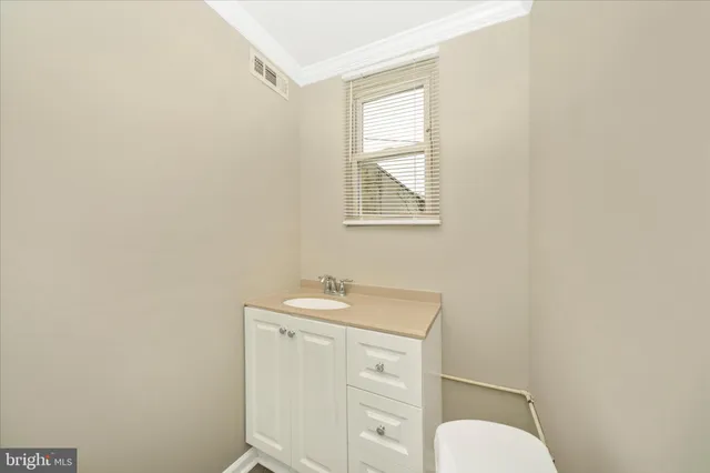 a bathroom with a toilet a sink and a window