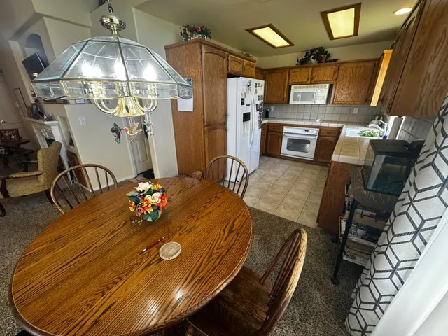 a view of a dining room with furniture a chandelier and wooden floor