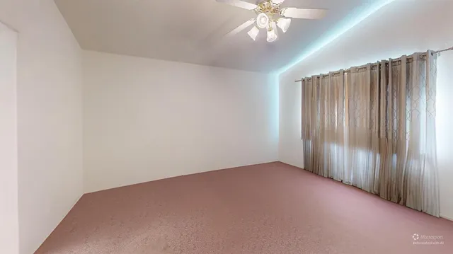 an empty room with a chandelier fan
