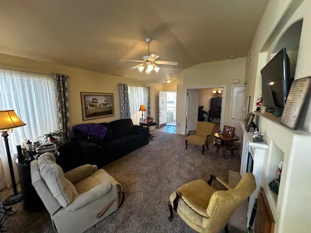 a living room with furniture a fireplace and a flat screen tv