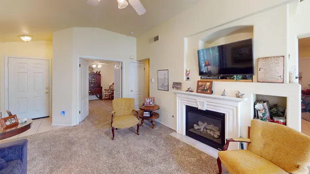 a living room with furniture a flat screen tv and a fireplace
