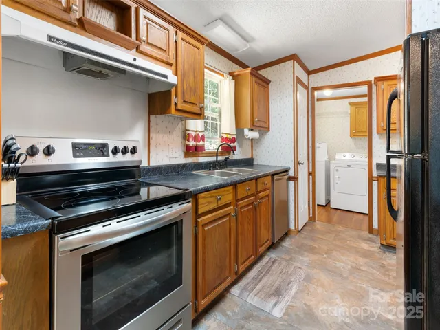 a kitchen with stainless steel appliances granite countertop a stove a sink and a refrigerator