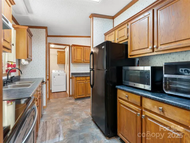 a kitchen with stainless steel appliances granite countertop a refrigerator and a stove top oven