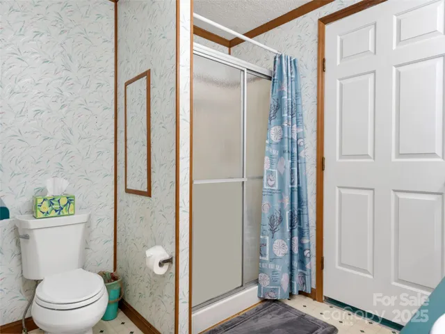 a bathroom with a granite countertop toilet a sink and a shower