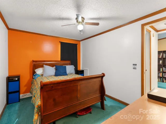 a bed sitting in a bedroom next to a window