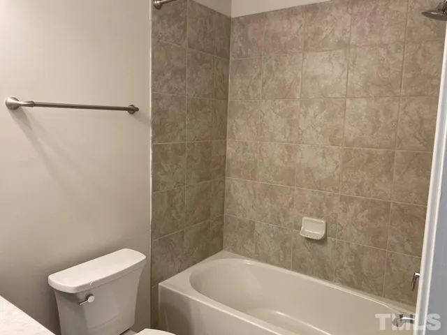 a white bath tub sitting next to a toilet