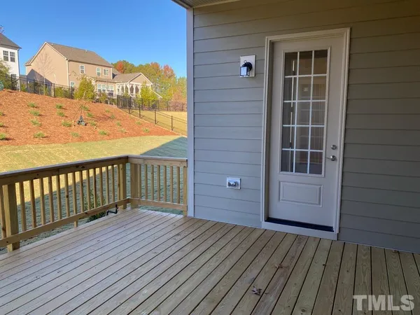 a view of a balcony with wooden floor and fence