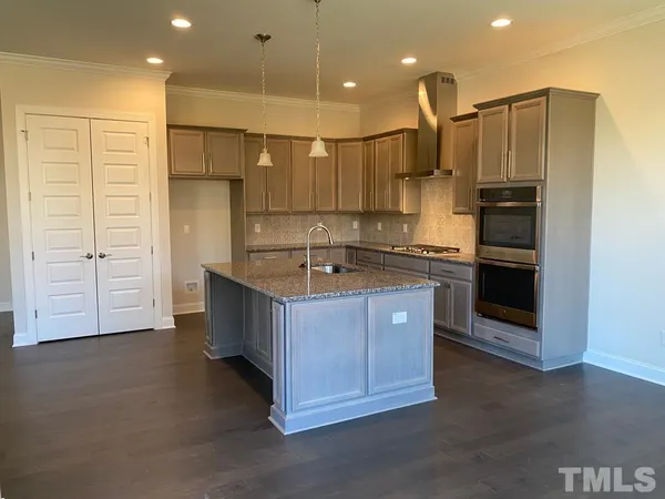 a kitchen with kitchen island cabinets and oven