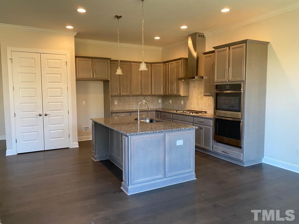 1185 St Cloud Loop Apex, NC 27523 - Photo 4 of 18 a kitchen with kitchen island cabinets and oven