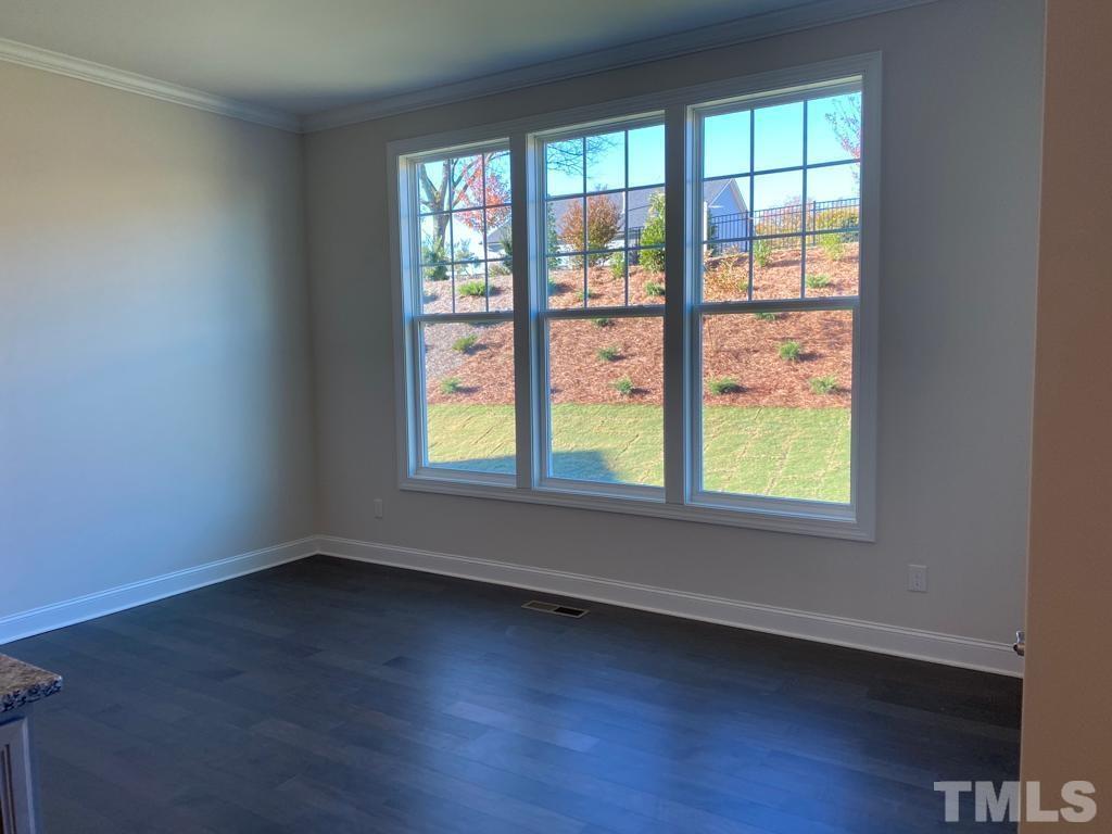 1185 St Cloud Loop Apex, NC 27523 - Photo 5 of 18 an empty room with wooden floor and windows