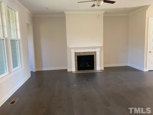 a view of an empty room with a fireplace and a window